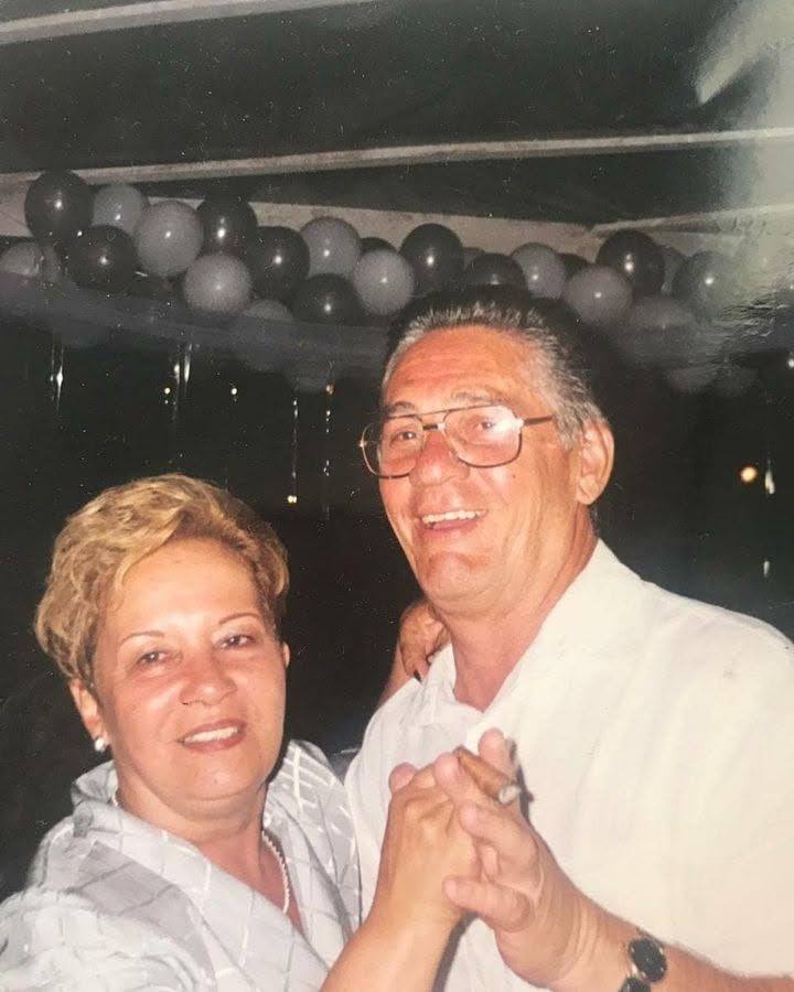 Tia Célia e Tuban dançando de mãos dadas em uma festa.